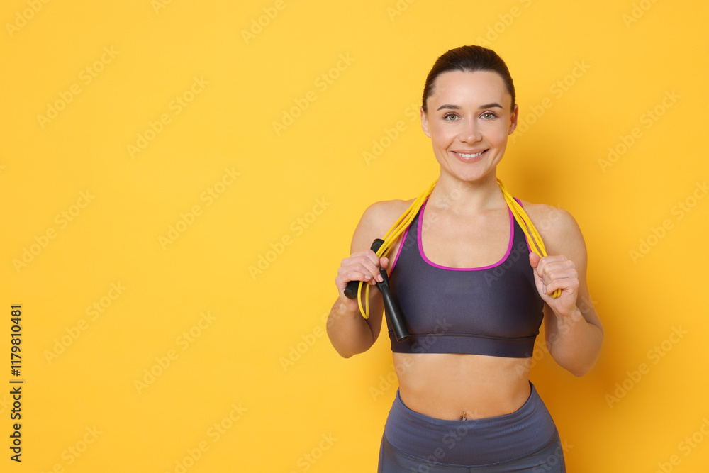 Smiling woman with skipping rope on yellow background. Space for text Smiling woman with skipping rope on yellow background. Space for text