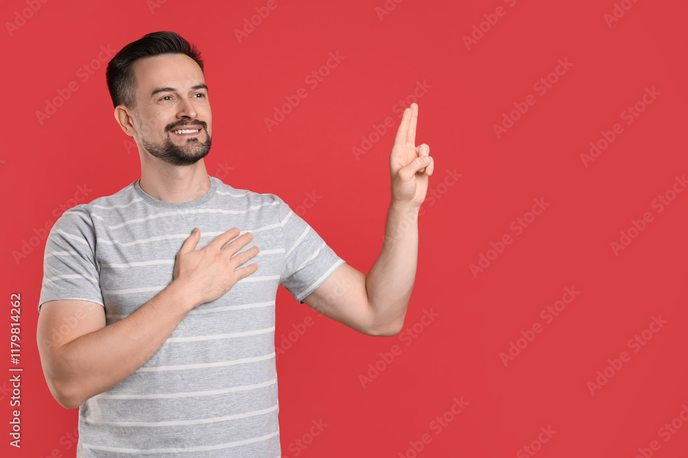 Man showing oath gesture on red background, space for text. Making promise Man showing oath gesture on red background, space for text. Making promise