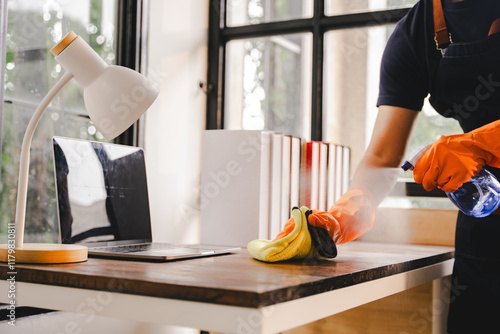 Cleaning staff used cloths and sprayed disinfectant. Wipe down tables and floors in the office. Concept of cleaning staff with equipment