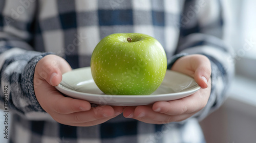 Fat, overweight and obese male kid having a green apple fruit on the plate for lunch or breakfast meal. calories dieting for weight loss, healthy nutrition. sugar addiction and diabetes. photo