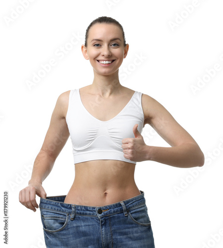 Weight loss. Happy woman wearing big jeans and showing thumbs up on white background photo