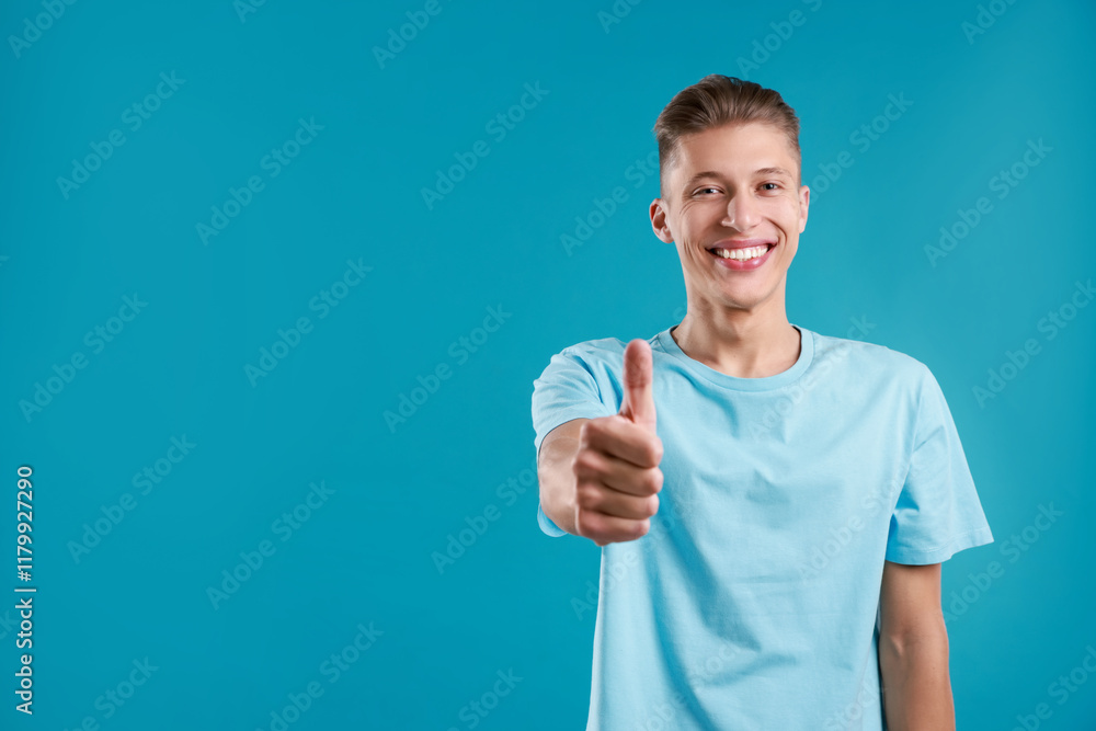 Happy man showing thumbs up on light blue background, space for text. Like gesture Happy man showing thumbs up on light blue background, space for text. Like gesture