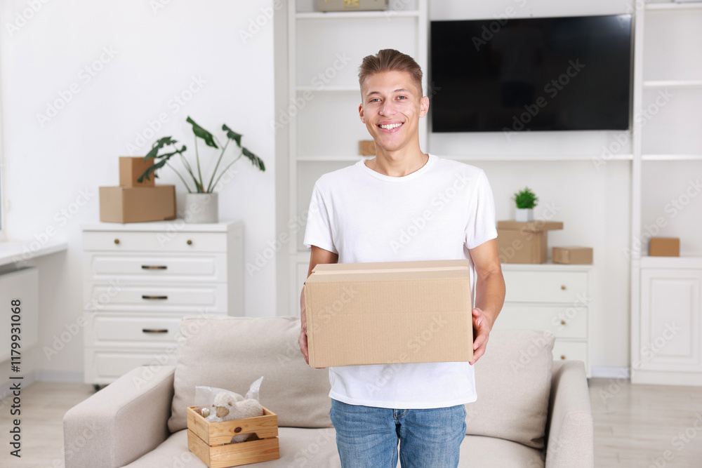 Fototapeta premium Happy man with moving box in new apartment. Housewarming party