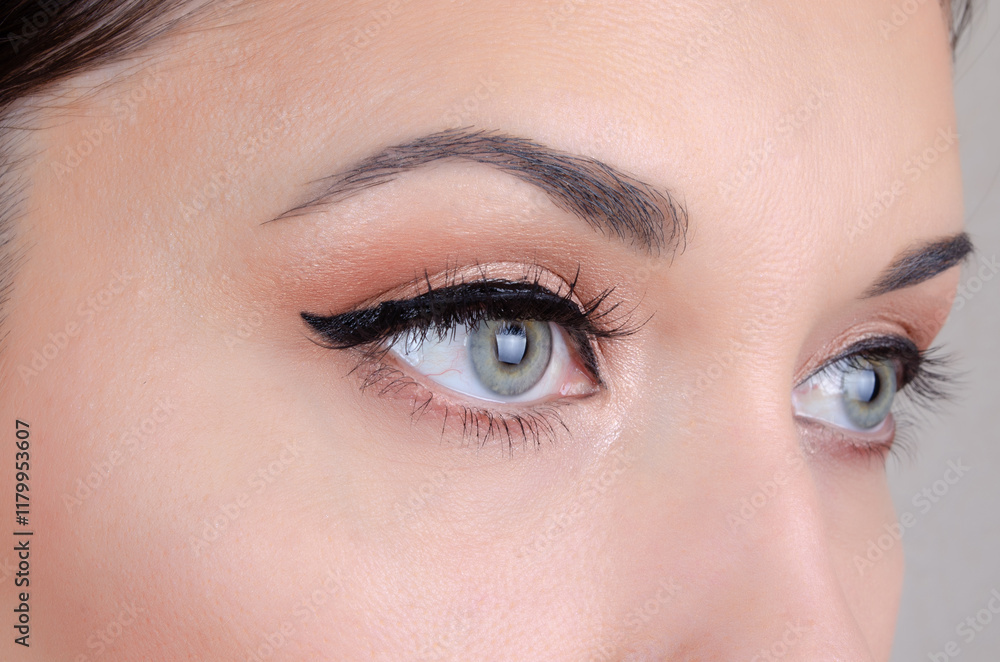 Fototapeta premium Elegant close-up of green female eyes with eyeliner and natural makeup