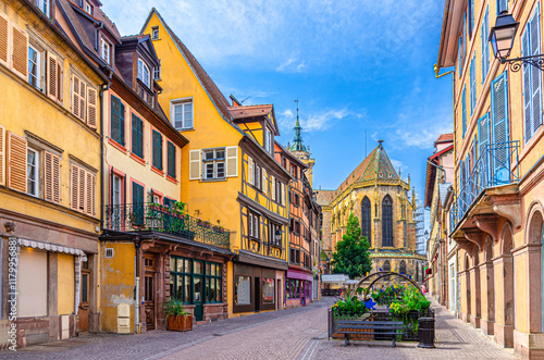 Old houses half-timbered colorful facade, medieval buildings shutters windows on Rue de l'Église street, Saint-Martin church in old town Colmar city historic centre, Alsace Grand Est region, France photo