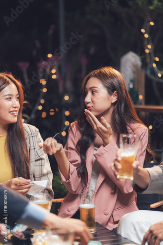 Night Out Laughter: A group of friends enjoys a lively conversation over drinks at a dimly lit outdoor bar.  The image captures the warmth and conviviality of a social gathering.