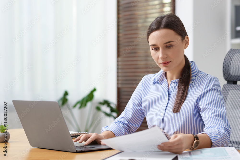 Businesswoman with document working at table in office Businesswoman with document working at table in office