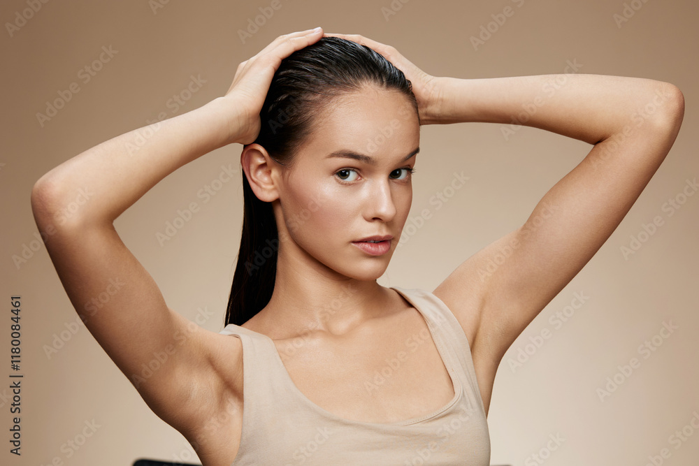 Young woman with long hair posing against a neutral background, showcasing healthy hair and natural beauty, highlighting self care and confidence