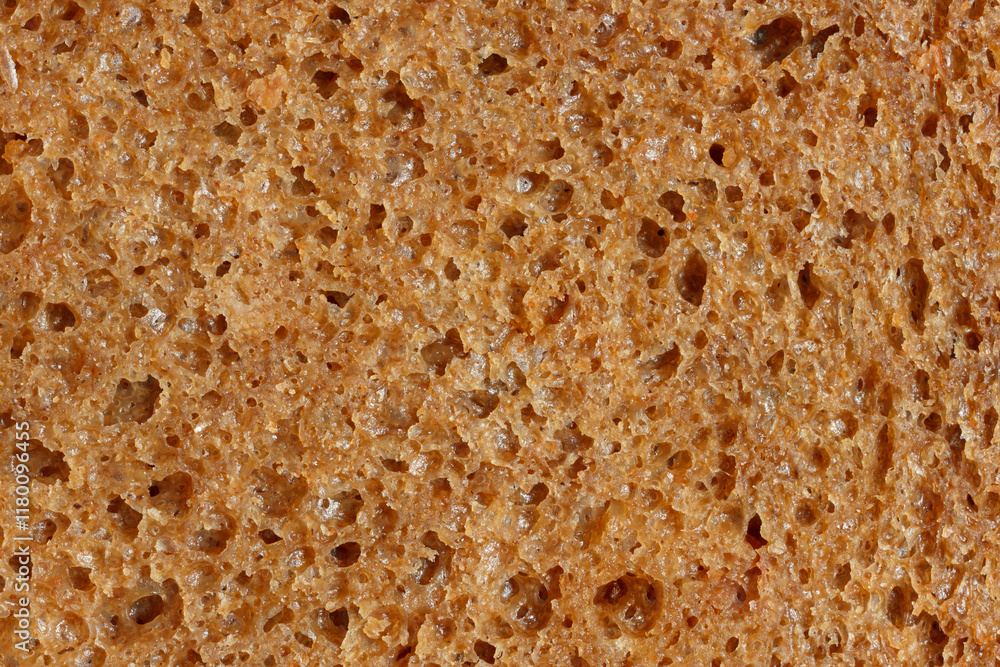 The sourdough brown bread slice in macro view. Texture of natural dark bread with porous for healthy nutrition The sourdough brown bread slice in macro view. Texture of natural dark bread with porous for healthy nutrition