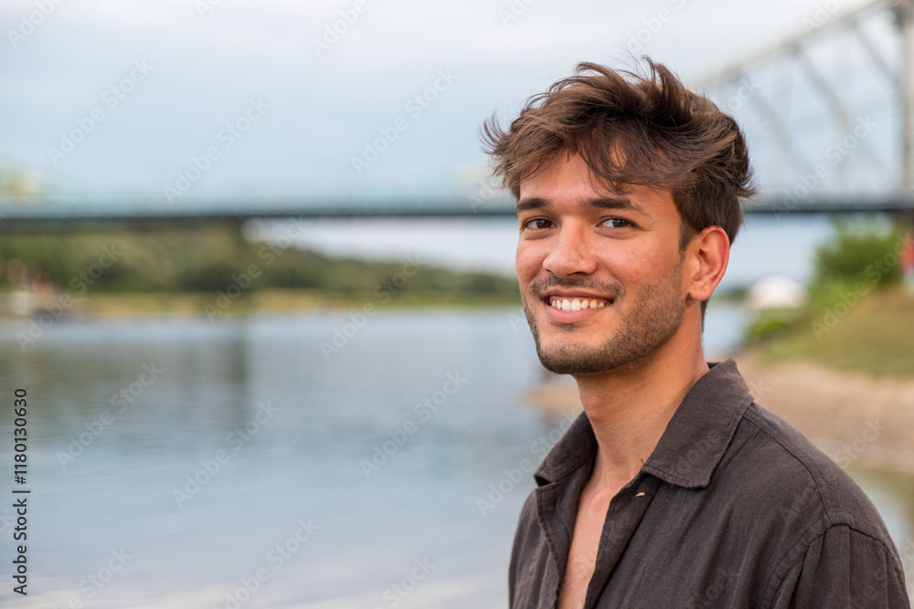 Junger Mann aus Indien seht am Fluss und posiert für die Kamera Junger Mann aus Indien seht am Fluss und posiert für die Kamera