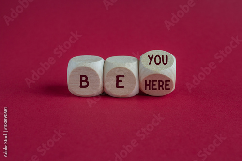 Be you and here symbol. Wooden cubes with words Be here Be you. Beautiful pink background. Business motivational be you and here concept.