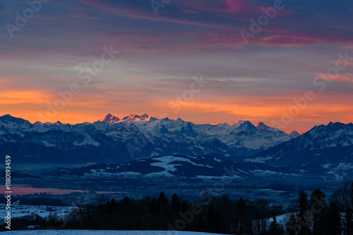 Sunrise over the Swiss Alps with orange glow over Eiger, Mönch and Jungfrau in winter