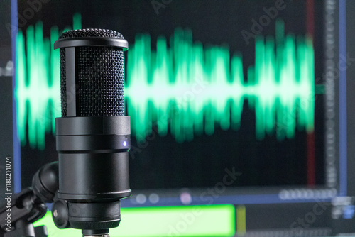 Professional studio microphone with a green audio waveform on a monitor, recording and podcast setup close-up