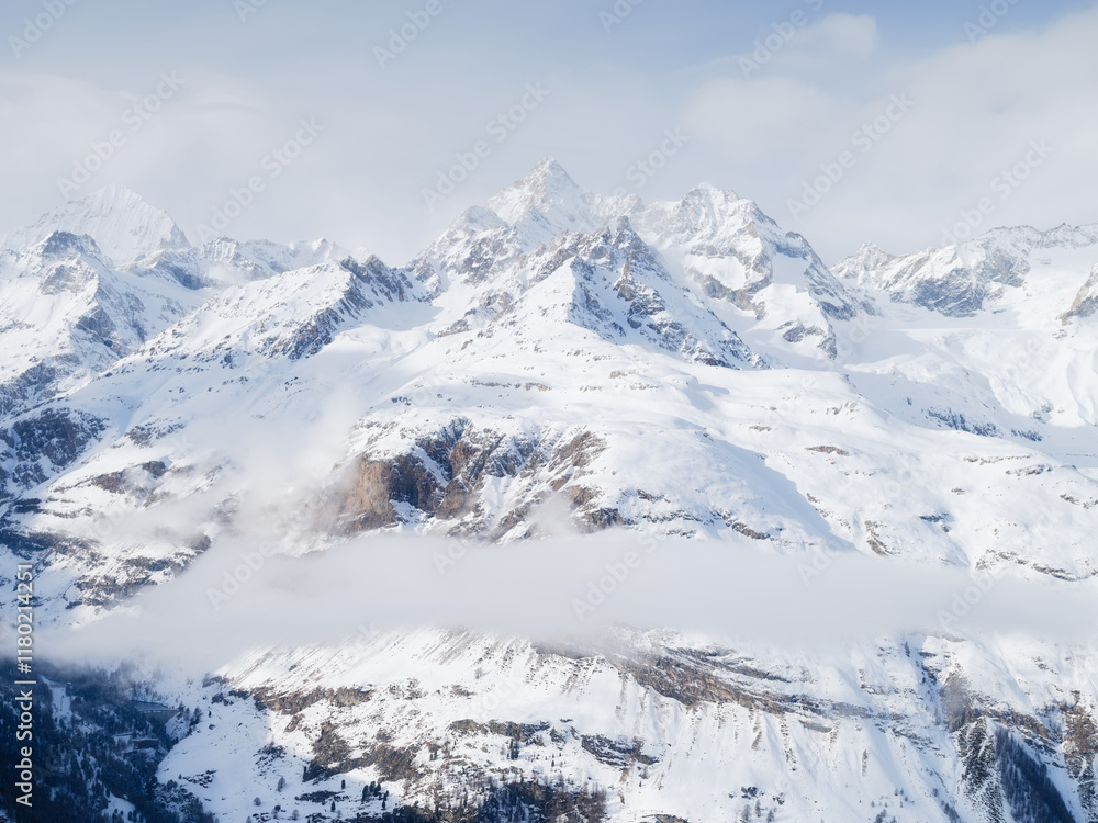 Obraz premium Winter mountain scene. High sharp rocks and snow. Cold weather and frost. View of the mountains. Photo for postcards, backgrounds, wallpapers.