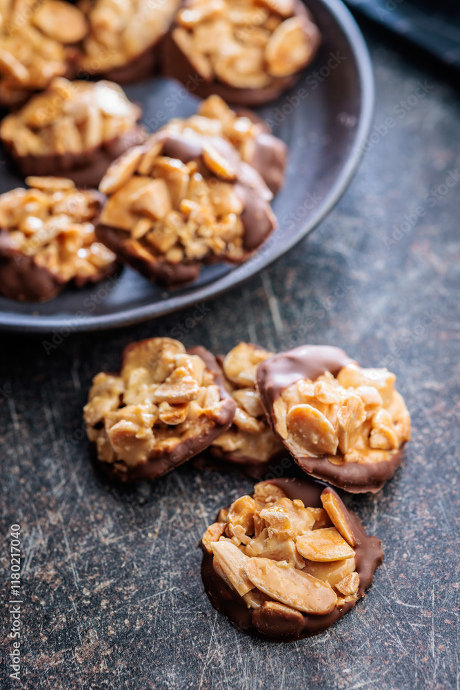 Photography of chocolate Florentines cookies with almonds and chocolate on black table. Photography of chocolate Florentines cookies with almonds and chocolate on black table.
