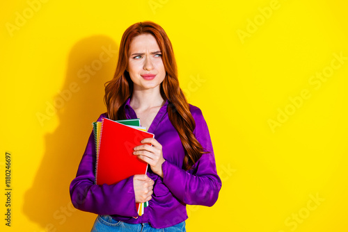 Photo portrait of lovely young lady copybooks look skeptical empty space dressed stylish violet garment isolated on yellow color background photo