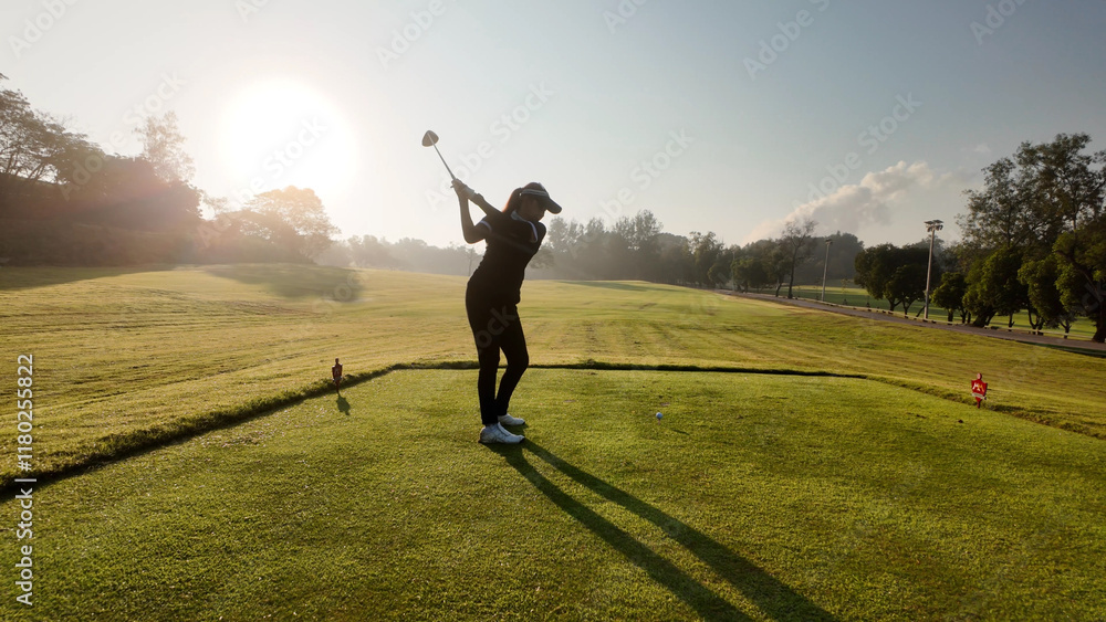 Woman playing golf on beautiful course , swinging and hitting golf ball , luxury vacation