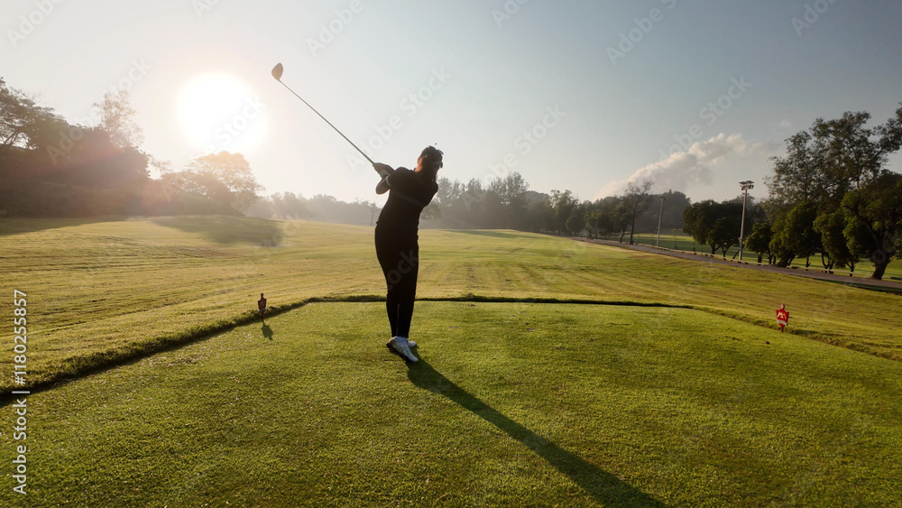 Woman playing golf on beautiful course , swinging and hitting golf ball , luxury vacation