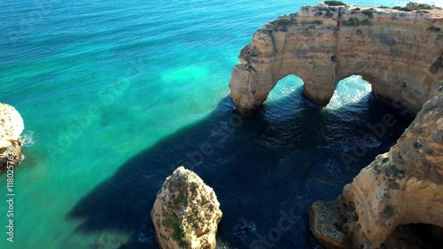 Portugal Algarve 4K cinematic drone of Praia da Marinha Iconic Double Arch in Shape of M with Orange Cliffs and Turquoise Sea Scenic Atlantic Coastline Most Beautiful Beach Travel