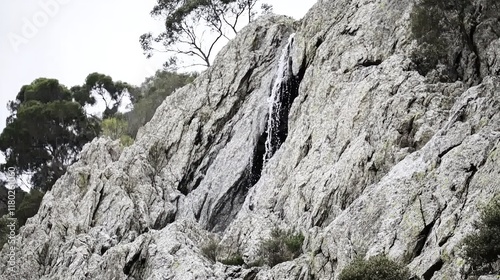 Rocky cliff face waterfall cascading down.