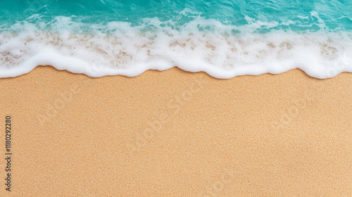 Foamy turquoise ocean waves gently meeting a smooth golden sandy beach photo