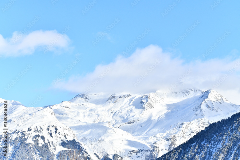Fototapeta premium French alps on a sunny day under the clouds by winter covered with snow