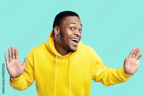 Funny Curious African American Guy Looking And Listening To You Posing Near Invisible Glass Wall Overhearing Standing Over Blue Studio Background. Curiosity And Eavesdropping Concept. Panorama photo