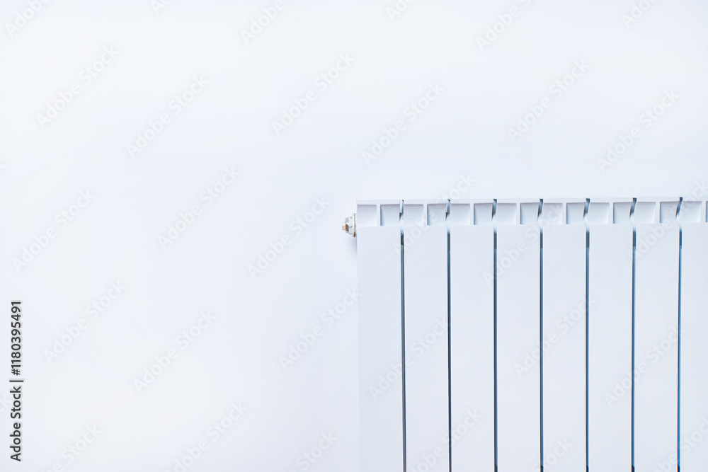 A minimalist view of a white radiator against a pale wall, showcasing sleek lines and a modern aesthetic. A minimalist view of a white radiator against a pale wall, showcasing sleek lines and a modern aesthetic.