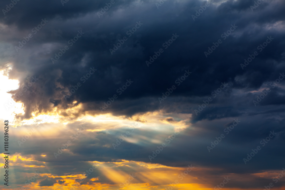 Obraz premium Sky is filled with dark, heavy clouds that blanket the horizon, atmosphere of looming anticipation. Dense formations cast shadowy hue across landscape, enveloping everything in muted and somber light