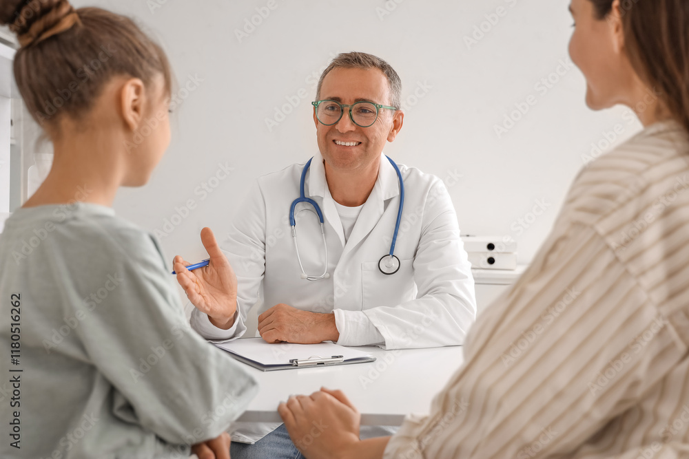 Male pediatrician working with little girl and mother in clinic Male pediatrician working with little girl and mother in clinic