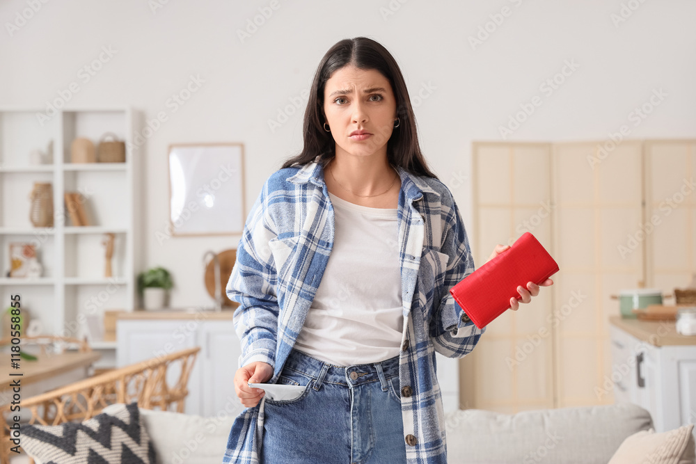 Upset young woman with empty pocket and wallet at home Upset young woman with empty pocket and wallet at home