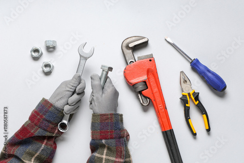 Wallpaper Mural Mechanic's hands with bolt and tools on grey background Torontodigital.ca