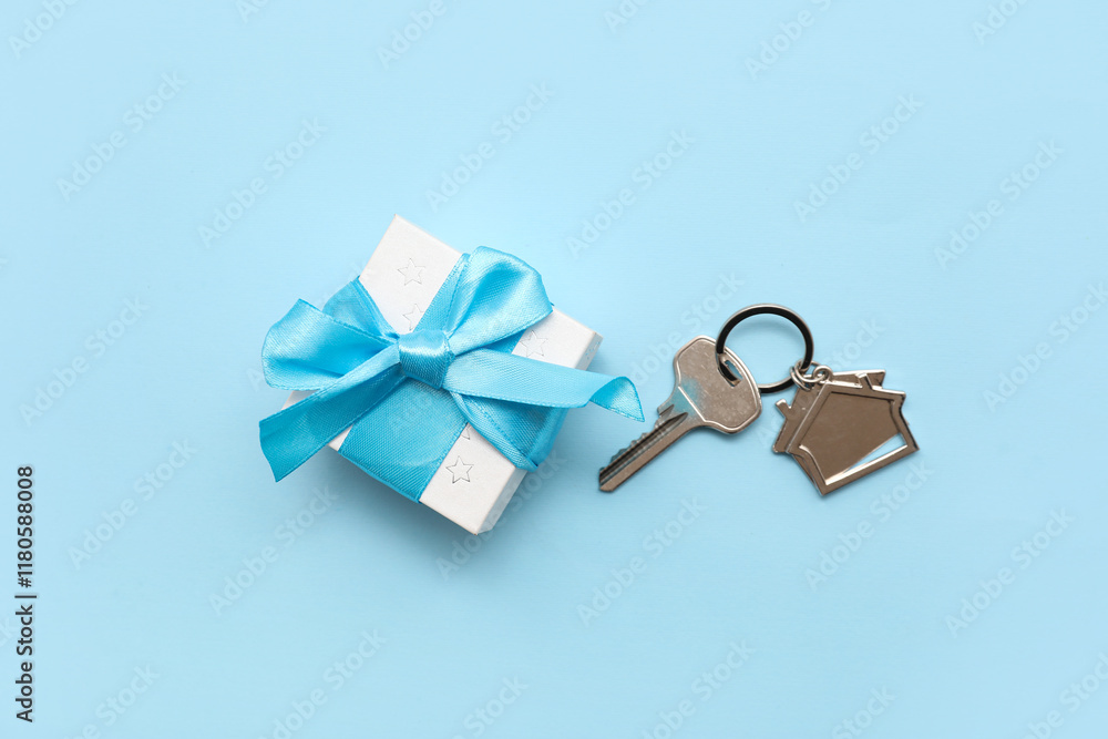 Φωτογραφία Key from house with gift box on blue background