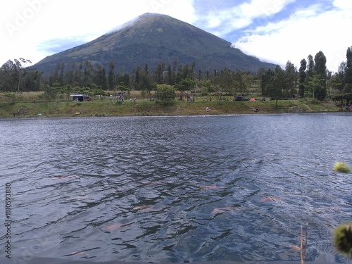 landscape view of mount Sindoro in Embung Kledung Temanggung central java indonesia with an artificial lake and swimming fish suitable for background wallpaper notes and design photo