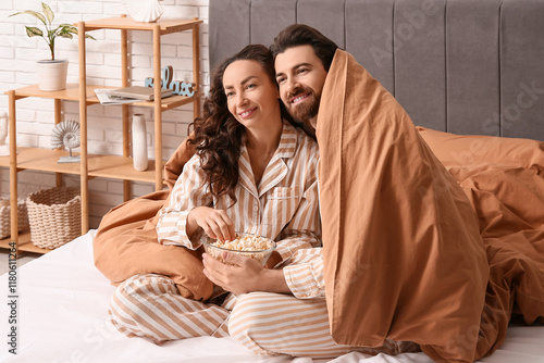 Happy couple in pajamas wit...