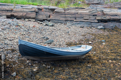 Old traditional wooden boat on the shore of the White Sea at low tide photo