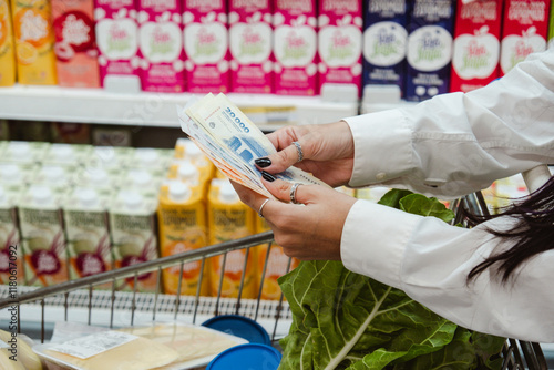 Woman Buying Food And Counting Money - Argentine Pesos - In The Supermarket. Concept Related To Inflation And Economic Crisis photo