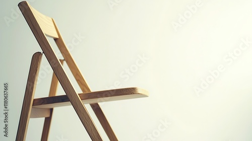 A wooden chair is upside down and leaning against a wall