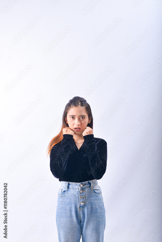 A young Asian Woman in a Black Velvet Top and Denim Jeans making expressive gestures Isolated on white background A young Asian Woman in a Black Velvet Top and Denim Jeans making expressive gestures Isolated on white background