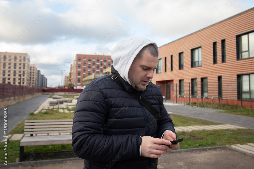 Man using smartphone outdoors in city, browsing social media, typing messages online with a digital gadget. Man using smartphone outdoors in city, browsing social media, typing messages online with a digital gadget.