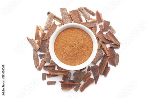 A bowl of Organic Cinnamon sticks (Cinnamomum verum) powder, placed over a heap of Cinnamon sticks. Isolated on a white background. photo