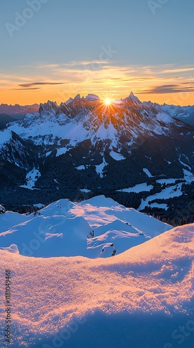Snow-covered mountain range with glowing sunrise