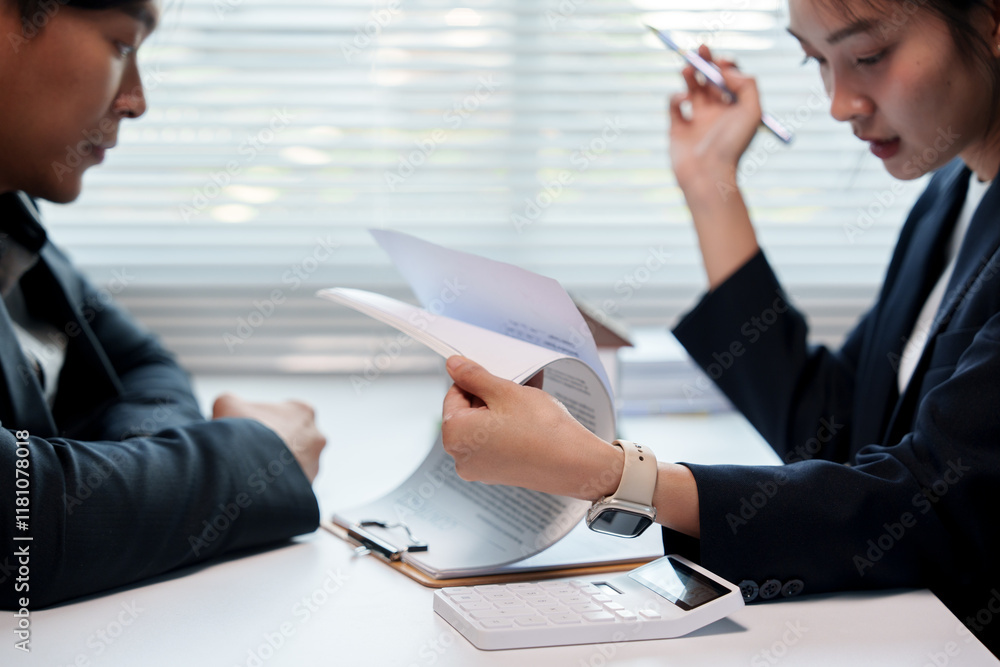 Businesswoman holding and reading documents, discussing with businessman, calculating and analyzing financial data, planning and preparing reports in the office Businesswoman holding and reading documents, discussing with businessman, calculating and analyzing financial data, planning and preparing reports in the office