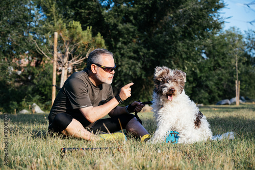 Fotografie Angry Man Scolding His Dog in a Park During a Sunny Afternoon