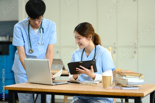 Fotografie Two medical students discussing and analyzing information on a laptop in modern