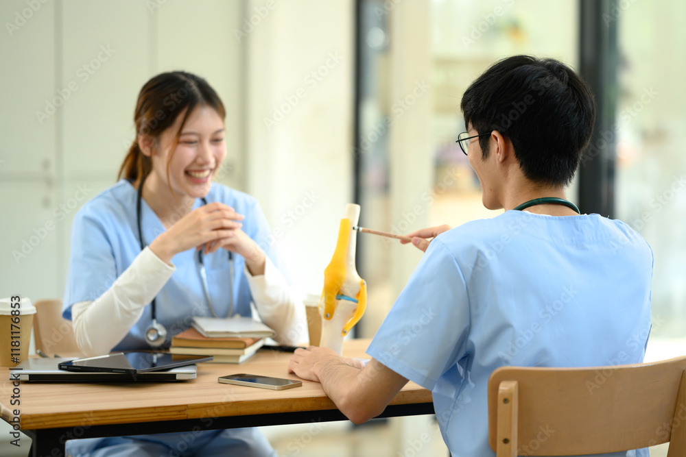Medical students in blue scrubs studying an anatomical mode in modern study area Medical students in blue scrubs studying an anatomical mode in modern study area