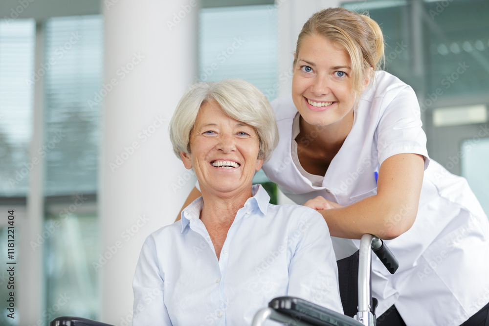 Obraz premium happy nurse taking care of a senior woman in wheelchair