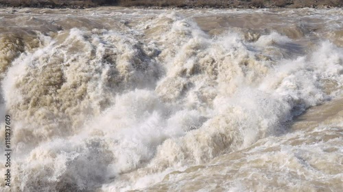 Hukou Waterfall in Shanxi Province, China, is a magnificent sight of the surging Yellow River water, filled with energy and awe inspiring，A fast flowing river photo