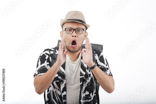 Handsome young Asian man wearing hat and backpack shouting and screaming loud. photo