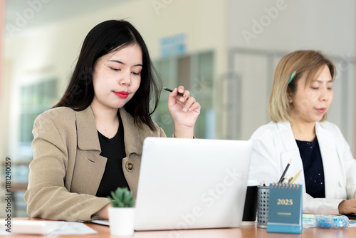 Businesswoman sitting at desk and working on laptop